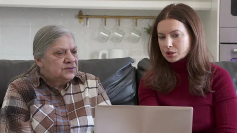 Bridging the Tech Gap: Daughter's Patient Guidance for Mom's Digital Journey Stock Footage 304789291