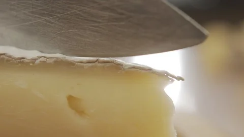 Brie cheese cut with sharp knife on wooden board in slow motion Stock Footage 120401924