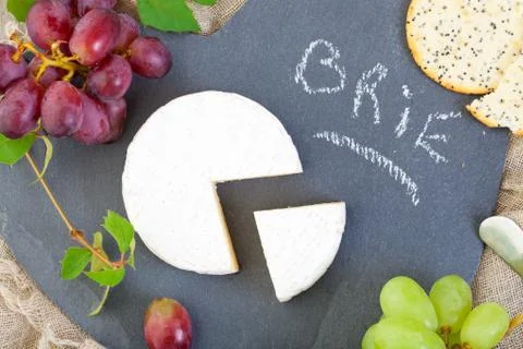 Brie cheese with grapes Stock Photos