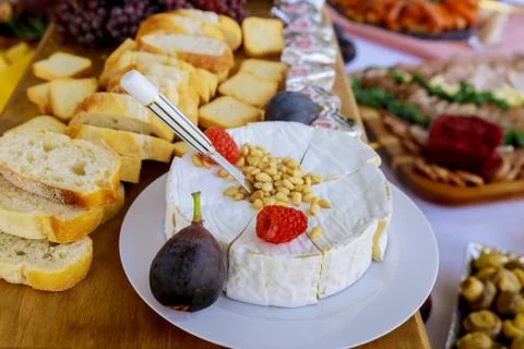 Brie cheese with nuts, bread and fruits. Stock Photos