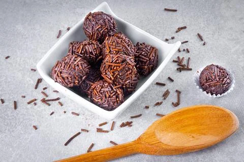 "Brigadeiro" candy in a white form next to others in a white bowl and woode.. Stock Photos