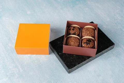 Brigadeiros inside a box on a marble stone. Next to the orange lid of the box Stock Photos