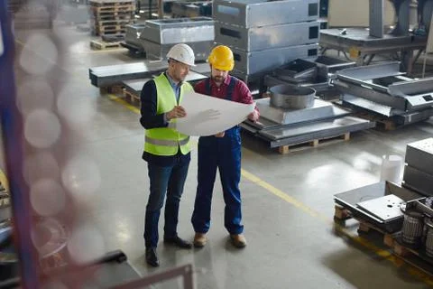 Brigadier explains to the engineer where to fix the drawings. Stock Photos