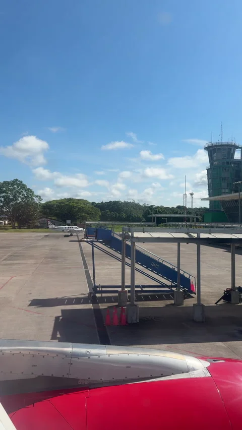 Bright Amazon Airport Apron with Red Jet Engine and Control Tower Stock Footage 338020374