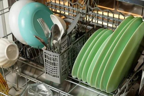 Bright and clean kitchen essentials drying in a modern dishwasher setup Stock Photos