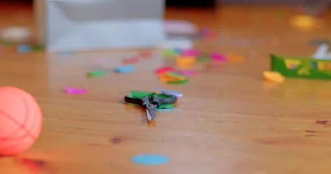 A Bright and Colorful Array of Confetti and Toys Scattered on a Wooden Floor Foto stock