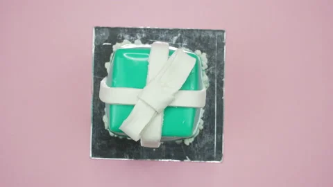 Bright and colorful cake gift close-up on a pink background. Rotating Top view. Stock Footage 87494844