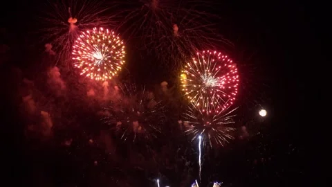 Bright and colorful exploding fireworks illuminate night sky with dynamic l.. Vídeos de archivo 337279236