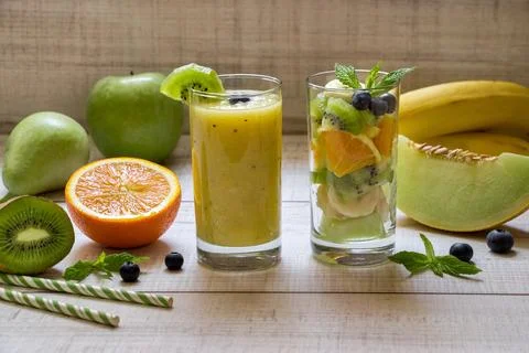 Bright and refreshing fruit smoothies and salad display on a wooden table Stock Photos