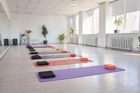 Bright and spacious yoga studio with lined colorful mats and blocks Stock Photos
