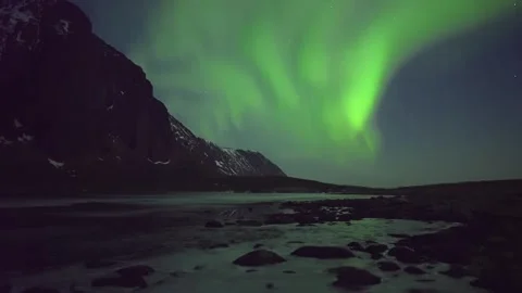 Bright Aurora Borealis Dances Over Snowy Arctic Mountains in Glowing Night Sky Stock Footage 308969334