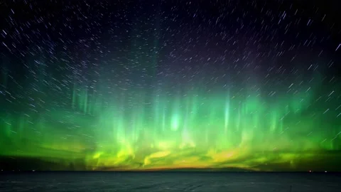 Bright Aurora dance across the sky above a frozen lake with stars forming comet  Stock Footage 171016408