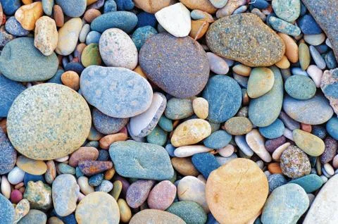 Bright background of multi-colored round stones, sea pebbles close up. Stock Photos