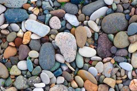 Bright background of multi-colored round stones, sea pebbles close up. Stock Photos