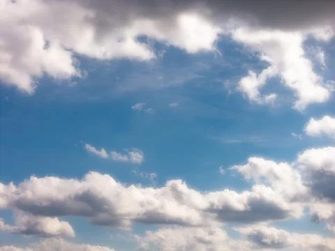 Bright Backlit Clouds Framing a Blue Opening 스톡 사진