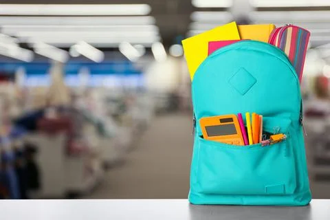 Bright backpack with school stationery on table in shopping mall. Space for t 写真素材