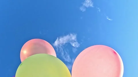 Bright balloons floating and shifting against blue sky Stock Footage 316385113