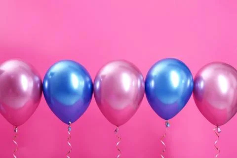 Bright balloons with ribbons on color background. Space for text Stock Photos