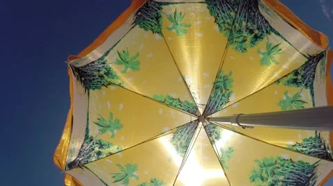 A bright beach umbrella swaying in the wind. Stock Footage