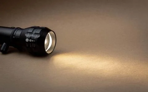 A bright beam of light from a flashlight shines on a brown recycled craft pap Stock Photos