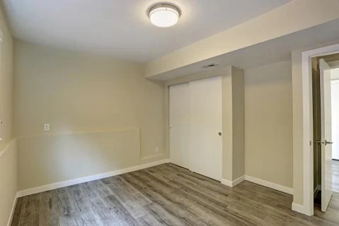 Bright beige empty room with grey hardwood floor, built-in closet. American h Stock Photos
