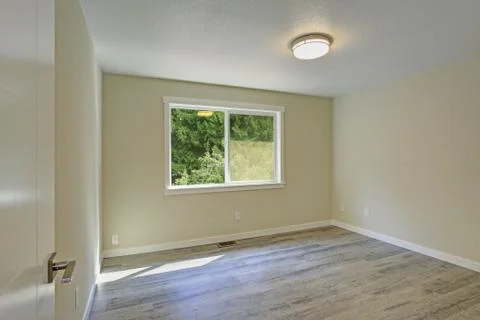 Bright beige empty room with grey hardwood floor. American house interior des Stock Photos