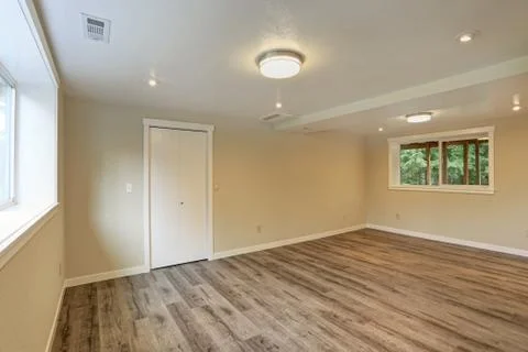 Bright beige large empty room with hardwood floor, built-in closet, small win Stock Photos