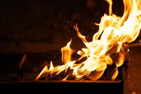 Bright blazing fire flames burning in outdoor metal brazier Stock Photos