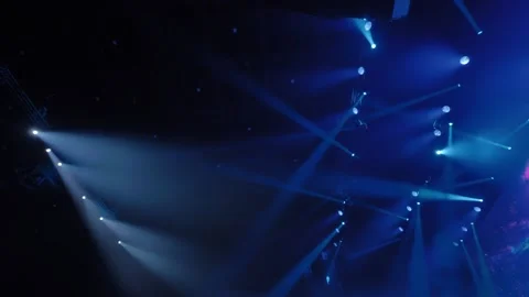 Bright blue and white stage lights illuminating dark concert hall Stock Footage 306019277