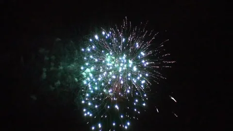 Bright blue fireworks exploding in the night sky during a celebration event Stock Footage 345852790