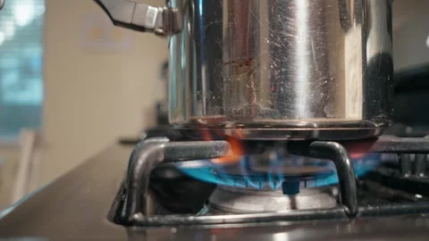 Bright Blue Gas Flame Heating a Stainless Steel Pot on a Modern Stovetop Stock Footage 318630627
