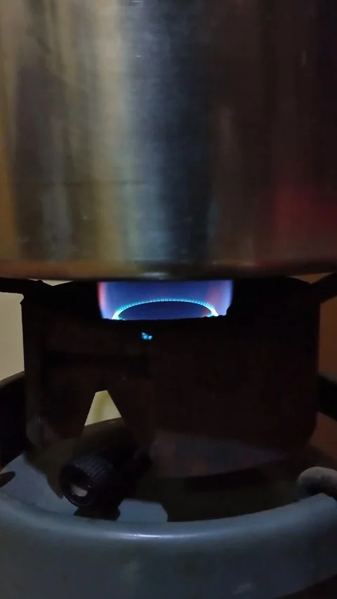 Bright blue gas flame heating stainless steel pot. Stock Footage 336590979
