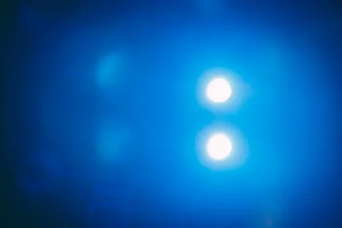 Bright blue light beams emanating from two circular sources, creating a vib.. Stock Photos
