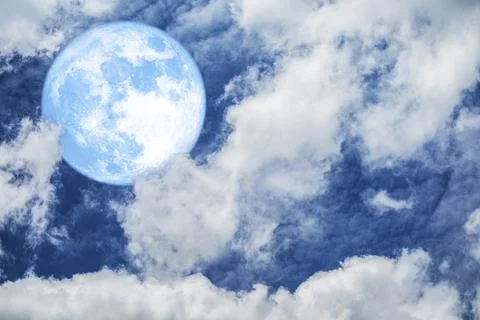Bright Blue Moon Surrounded by Fluffy Clouds in Evening Sky Stock Photos