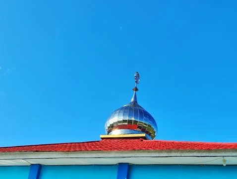 A bright blue mosque with silver domes and a red roof Stock Photos