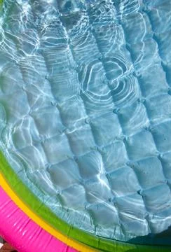 Bright blue paddling pool surface with water ripples Stock Photos