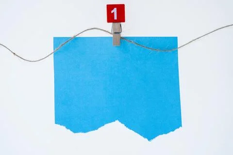Bright blue paper note held by a clothespin on a string against a white bac.. Stock Photos