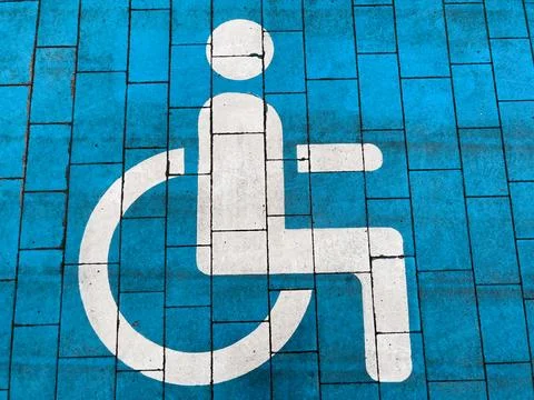 A bright blue pavement features a clear white symbol indicating accessible .. Stock Photos