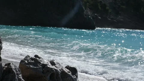 Bright blue sea waves rolling on a rocky shore on a sunny day Stock Footage 331214925