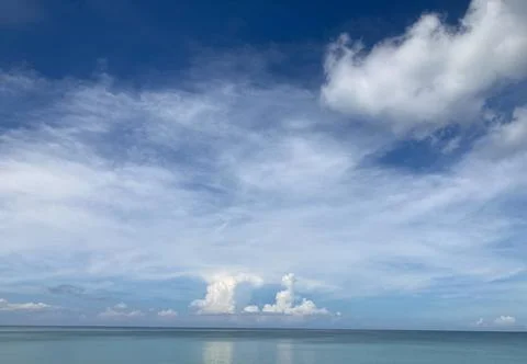 The bright blue sky with the amazing cloudscape reflects on the sea Stock Photos