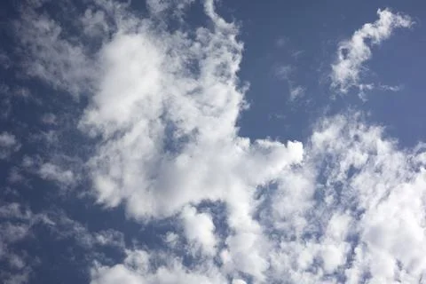Bright blue sky background texture with fluffy clouds Stock Photos