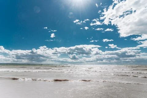 Bright blue sky with clouds over the sea with waves Stock Photos