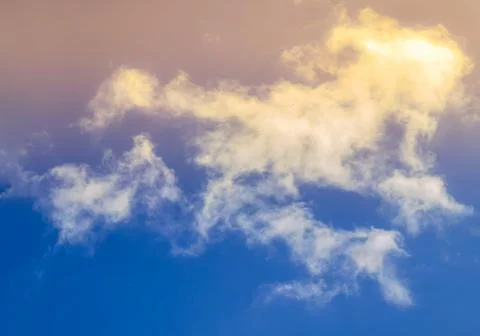 Bright blue sky with clouds with sunset lights, background for design, decora 写真素材