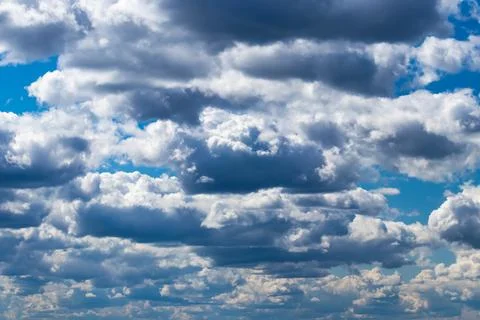 Bright blue sky with cumulus clouds lit by the daytime sun. Abstract backgr.. Stock Photos