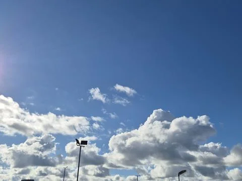 Bright blue sky with dramatic clouds and sunlight Stock Photos
