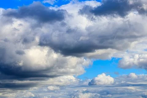 Bright blue sky with dramatic cumulus clouds lit by the daytime sun. Abstra.. Stock Photos