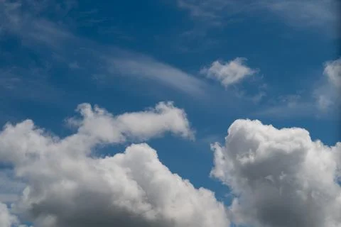 Bright blue sky featuring crisp cloud formations and spaciousness. Pristine a Stock Photos