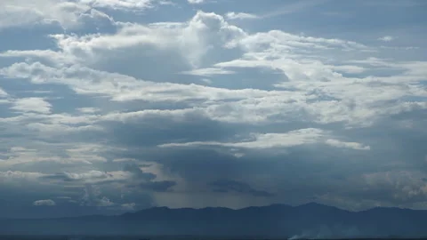 Bright blue sky with fluffy clouds over a mountain Stock Footage 277171898