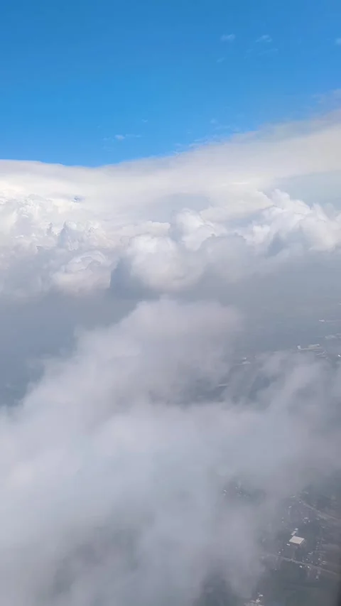 Bright blue sky with fluffy clouds, showing view of islands and cityscape below Video stock 312729607