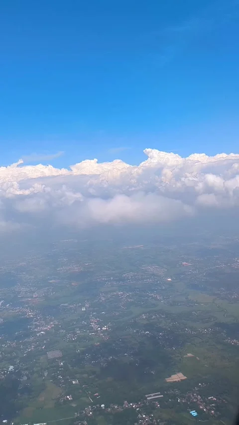 Bright blue sky with fluffy clouds, showing view of islands and cityscape below Video stock 312729743